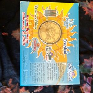 Disneyland commemorative coin from opening of Calif adventure packaging in tact